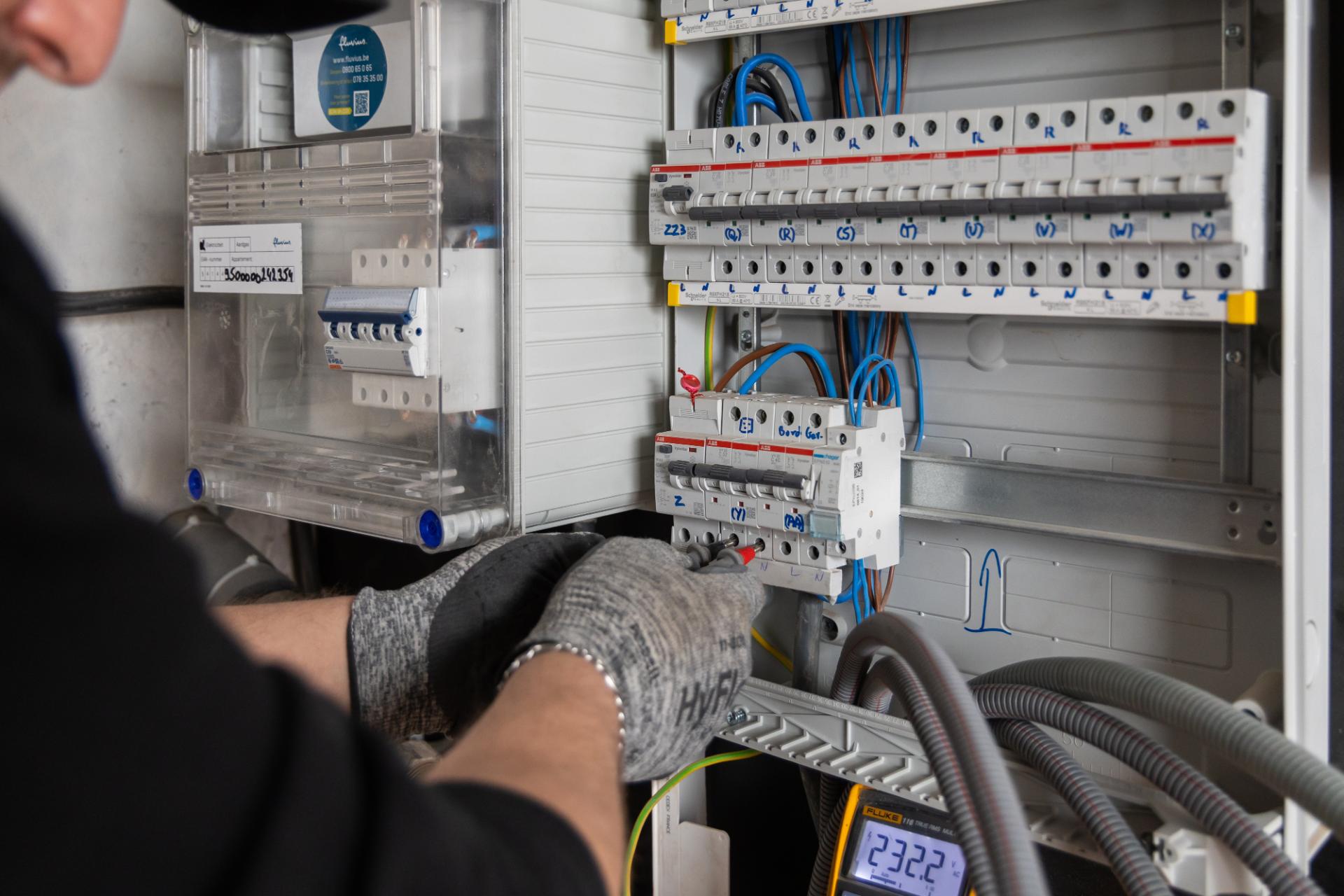 Elektricien werkt aan elektrische kast voor industriële installatie