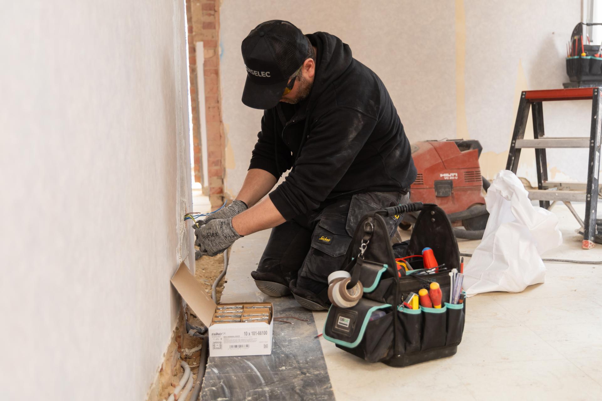 Elektricien voert installatie uit tijdens renovatie woning