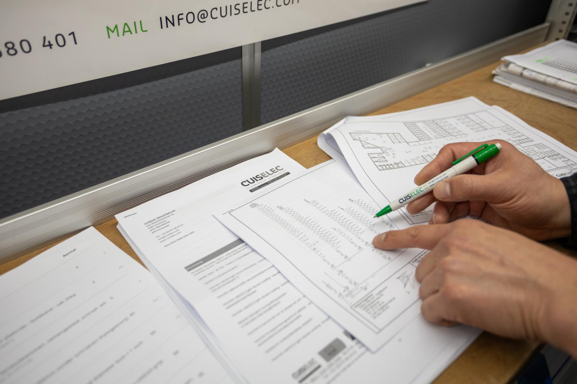 Elektricien controleert elektrisch schema met pen