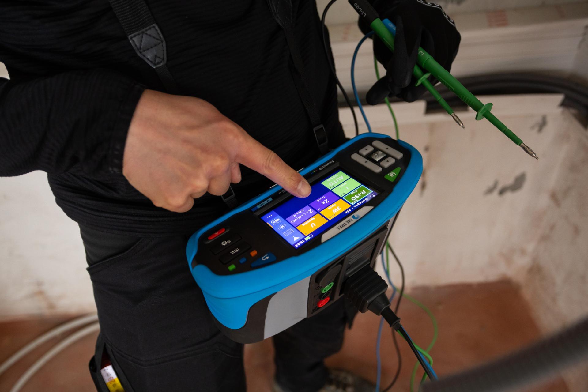 Elektricien controleert installatie met meettoestel voor isolatiemeting	