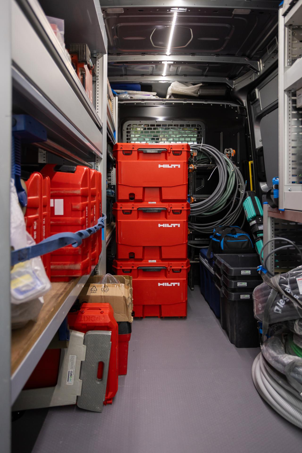 Opgestapelde Hilti koffers en materiaal in servicewagen