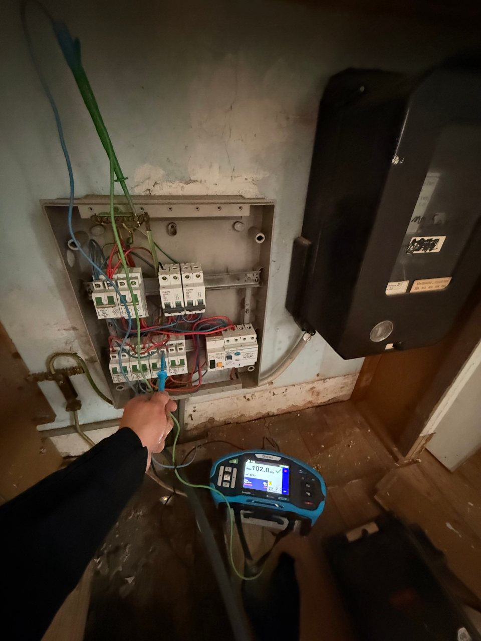 Meting met een installatietester aan een verouderde zekeringkast van een oude elektrische installatie